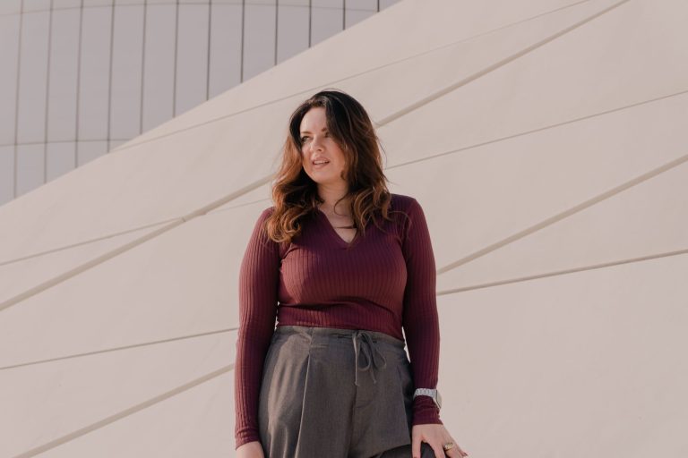 Femme portant un pantalon bordeaux assorti à un top clair, photo mode lifestyle