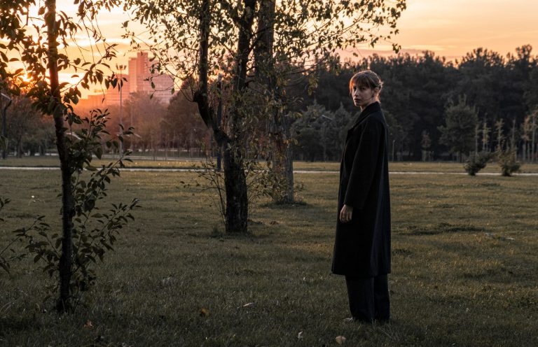 Femme en manteau élégant debout en extérieur, mettant en valeur la silhouette